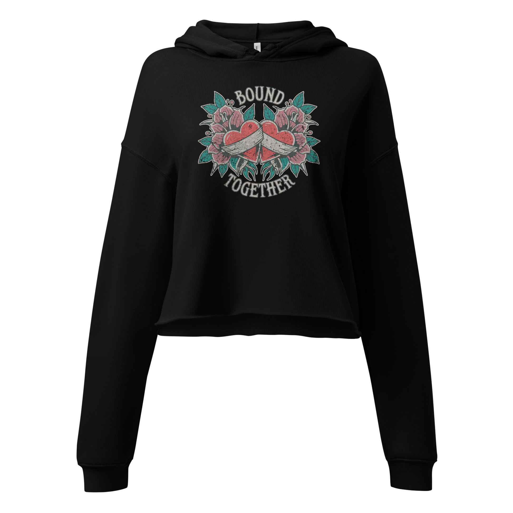 A Vintage Tattoo Inspired Design Featuring two red hearts wrapped together with a white ribbon, surrounded by pink flowers and green leaves in a symmetrical layout. The words 'BOUND' and 'TOGETHER' are displayed in bold, vintage-style serif typography above and below the hearts. The design is mocked up on a black Women's Bella + Canvas 7502 Cropped Hoodie 