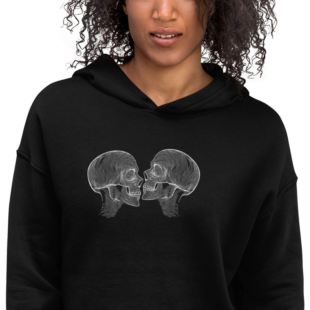 close up mock up detail shot of "Counterparts" design featuring two mirrored skulls with intricate white linework, symbolizing duality and connection, placed on a black cropped hoodie for a minimalist look.