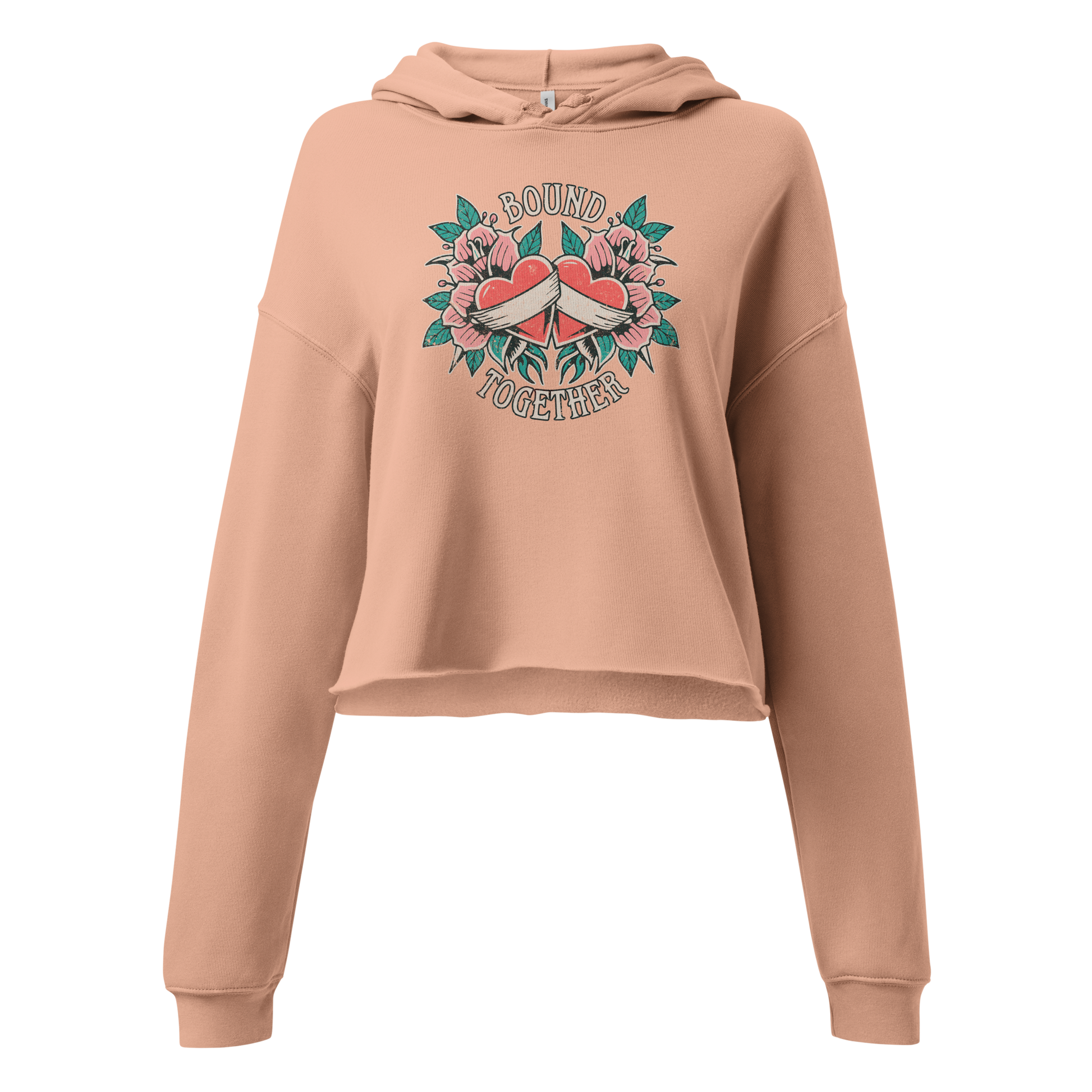 A Vintage Tattoo Inspired Design Featuring two red hearts wrapped together with a white ribbon, surrounded by pink flowers and green leaves in a symmetrical layout. The words 'BOUND' and 'TOGETHER' are displayed in bold, vintage-style serif typography above and below the hearts. The design is mocked up on a Peach Women's Bella + Canvas 7502 Cropped Hoodie Product mockup